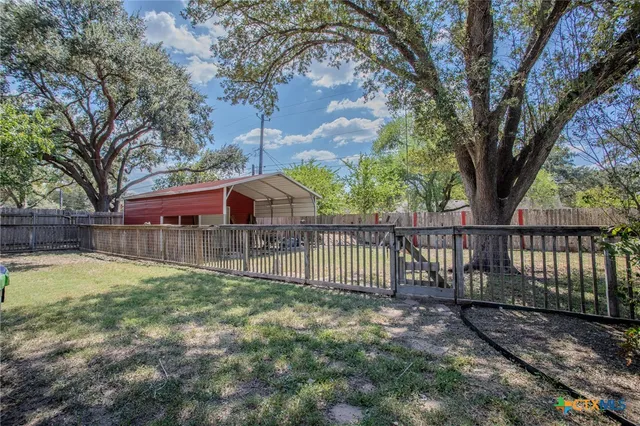 a view of a backyard with a large tree