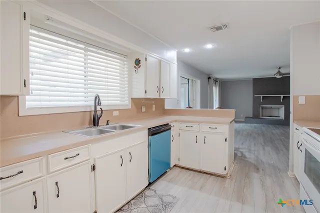 a kitchen with granite countertop white cabinets and white appliances