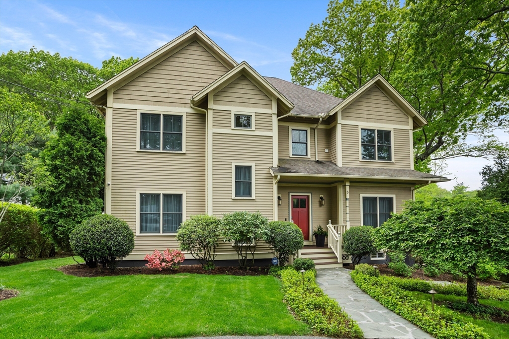 a front view of a house with a yard and trees