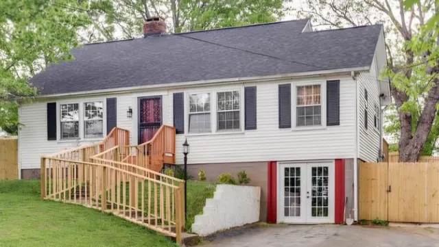 a view of a house with a small yard and wooden fence