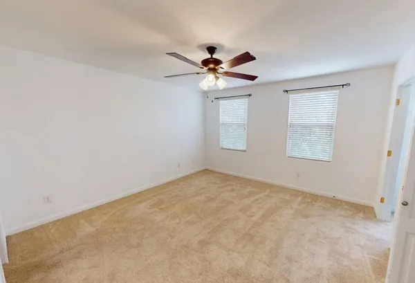 an empty room with closet and a ceiling fan