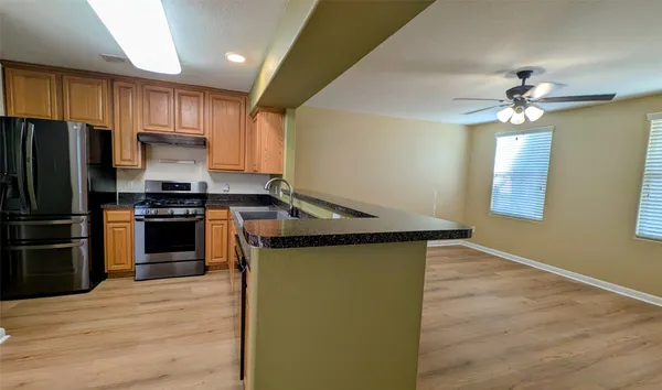 a kitchen with granite countertop a sink cabinets and wooden floor