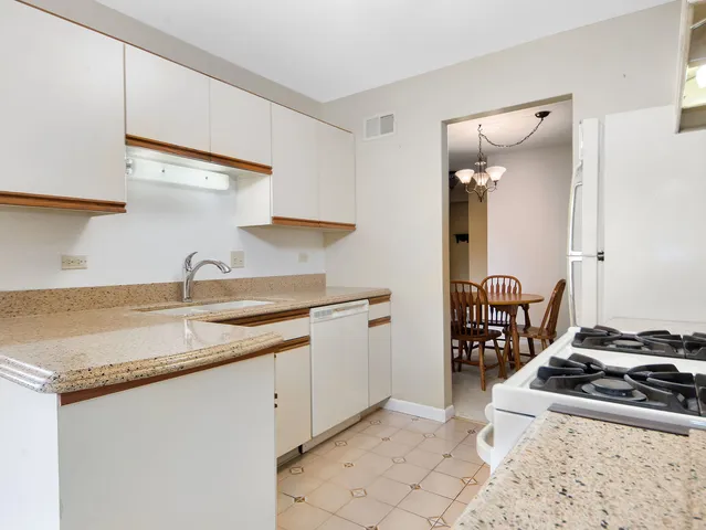 a kitchen with a refrigerator and white cabinets