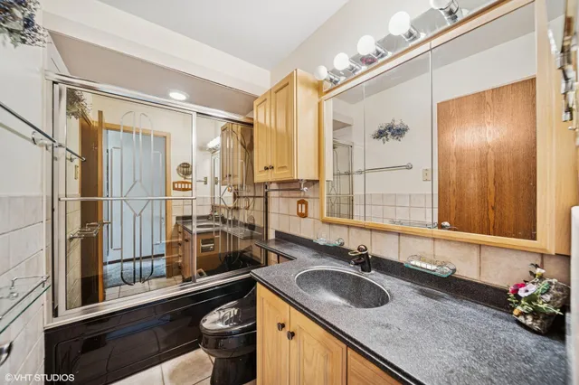 a bathroom with a granite countertop sink and a large mirror