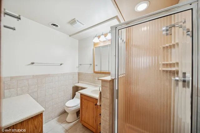 a bathroom with a granite countertop toilet a sink and shower