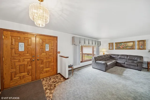 a living room with furniture and a chandelier