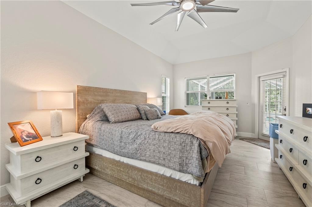 2039 Terrazzo Lane Naples, FL 34104 - Photo 13 of 29 a bedroom with a bed and a chandelier