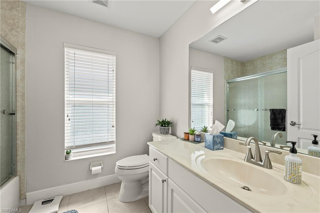2039 Terrazzo Lane Naples, FL 34104 - Photo 16 of 29 a bathroom with a granite countertop sink toilet a large mirror and a window