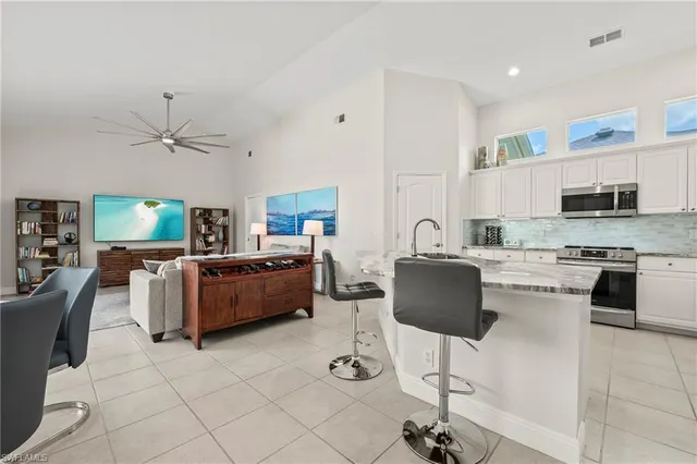 a living room with furniture and a view of kitchen