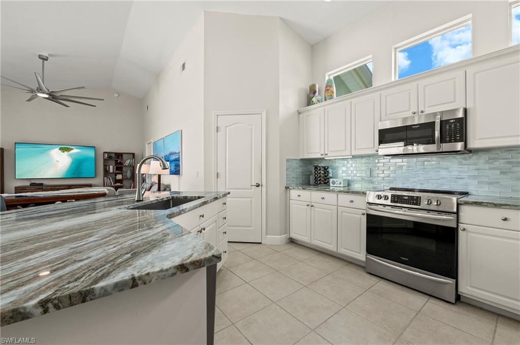 2039 Terrazzo Lane Naples, FL 34104 - Photo 7 of 29 a kitchen with stainless steel appliances granite countertop a stove microwave and sink