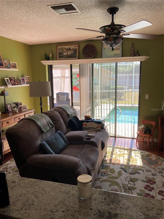 8101 Roxboro Drive Hudson, FL 34667 - Photo 29 of 47 a living room with furniture and a floor to ceiling window
