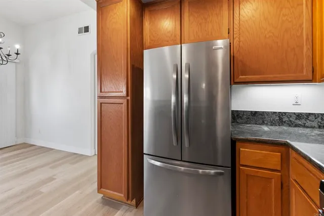 a metallic refrigerator freezer sitting in a kitchen