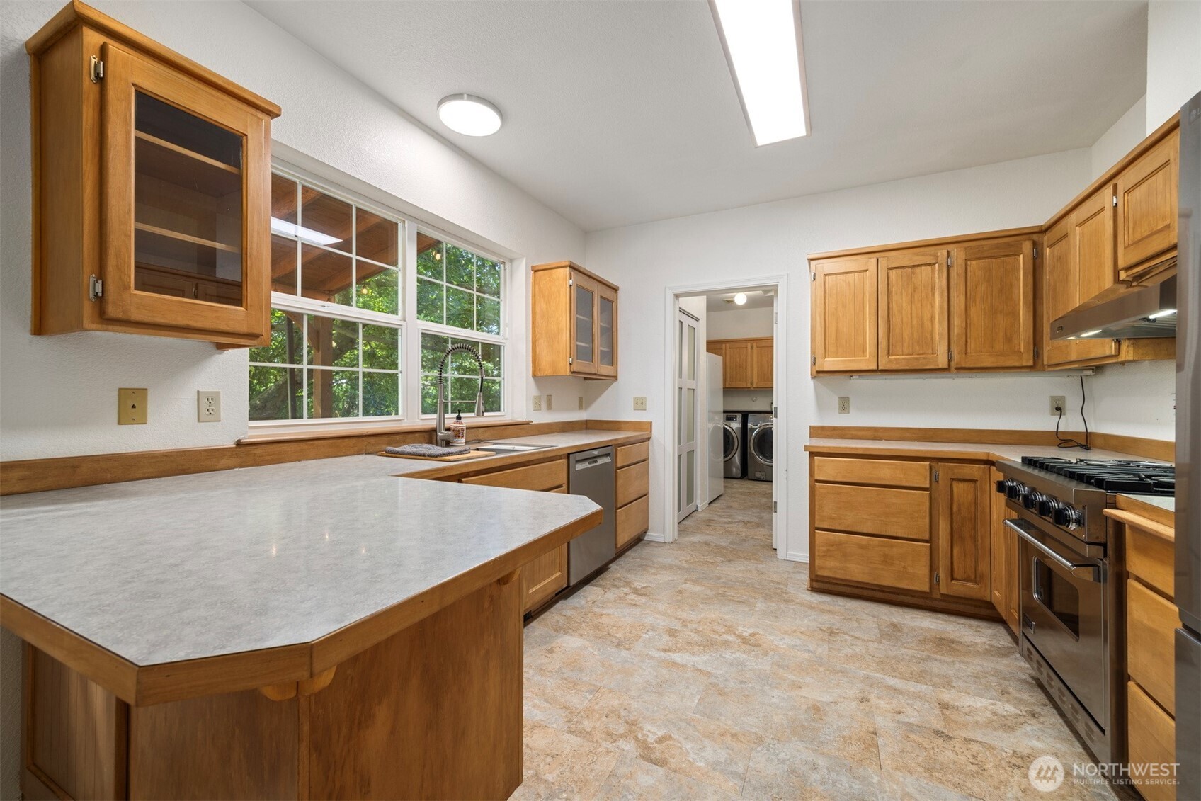 299 East Axton Road Bellingham, WA 98226 - Photo 27 of 40 a kitchen with stainless steel appliances granite countertop a stove a sink and a refrigerator