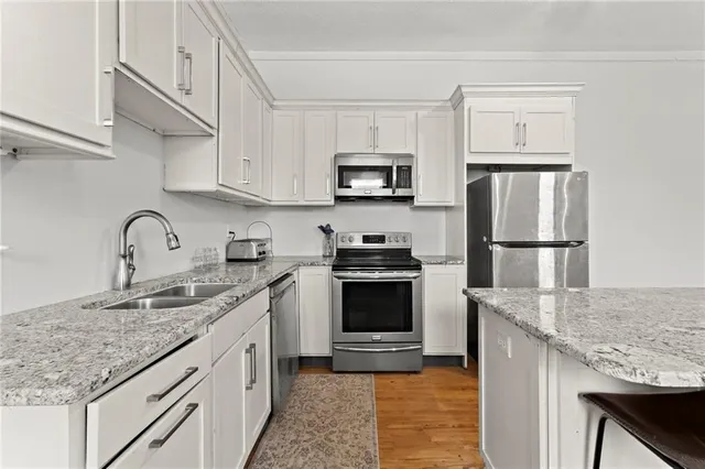 a kitchen with stainless steel appliances granite countertop a sink stove and refrigerator