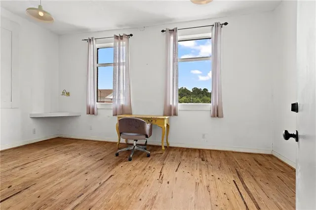 a view of a workspace with wooden floor and a window