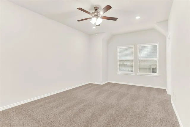 an empty room with a ceiling fan and a bathroom