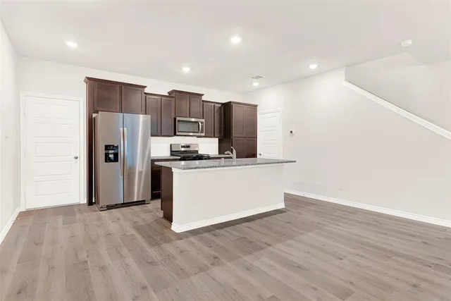a kitchen with stainless steel appliances a refrigerator and a stove top oven