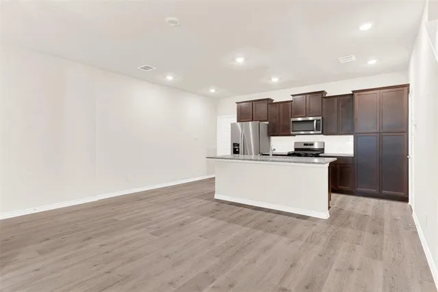 a kitchen with stainless steel appliances a refrigerator and a stove top oven