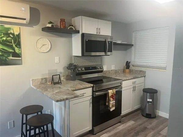 a kitchen with stainless steel appliances granite countertop a sink stove a microwave and cabinets