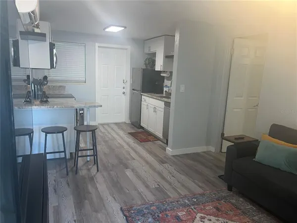 a kitchen with a table chairs refrigerator and a sink