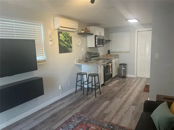 a kitchen with stainless steel appliances granite countertop a stove top oven a sink dishwasher and a refrigerator with wooden floor