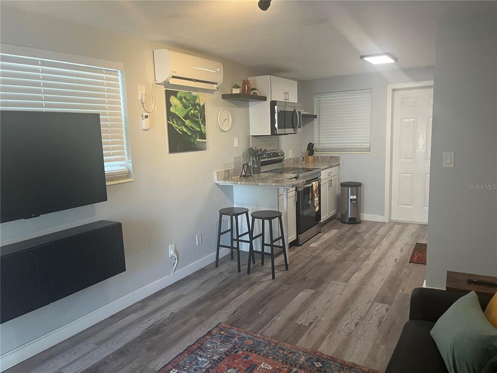 115 Cleveland Avenue Southwest Largo, FL 33770 - Photo 4 of 15 a kitchen with stainless steel appliances granite countertop a stove top oven a sink dishwasher and a refrigerator with wooden floor