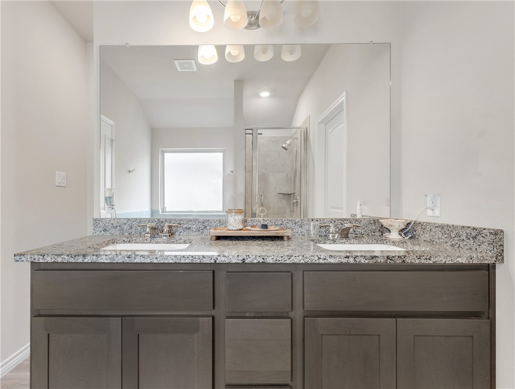 2016 Chief Street Bryan, TX 77807 - Photo 21 of 30 a bathroom with a granite countertop sink and a mirror