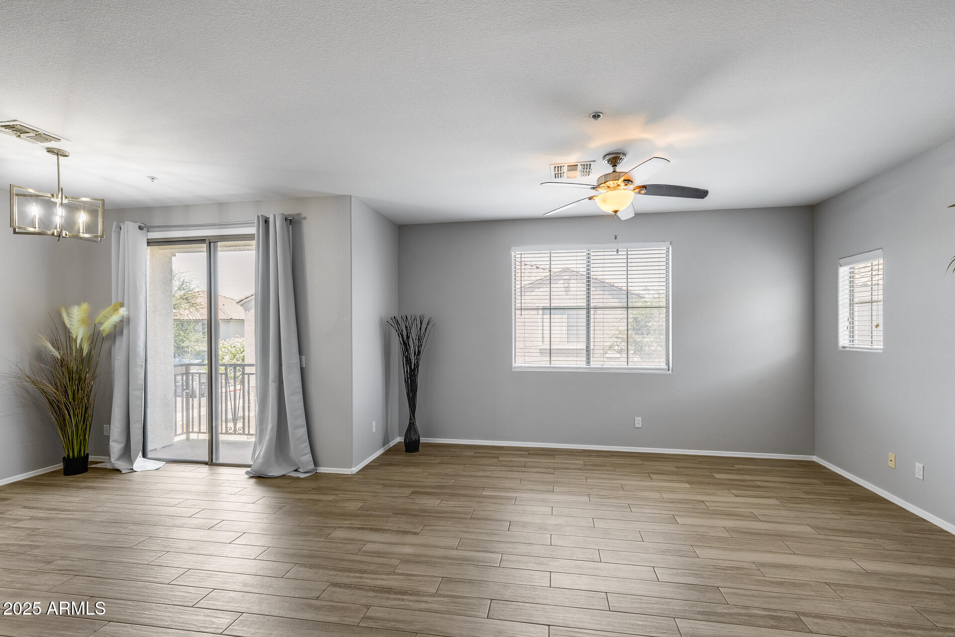 2941 East Darrow Street Phoenix, AZ 85042 - Photo 2 of 48 an empty room with wooden floor fan and windows