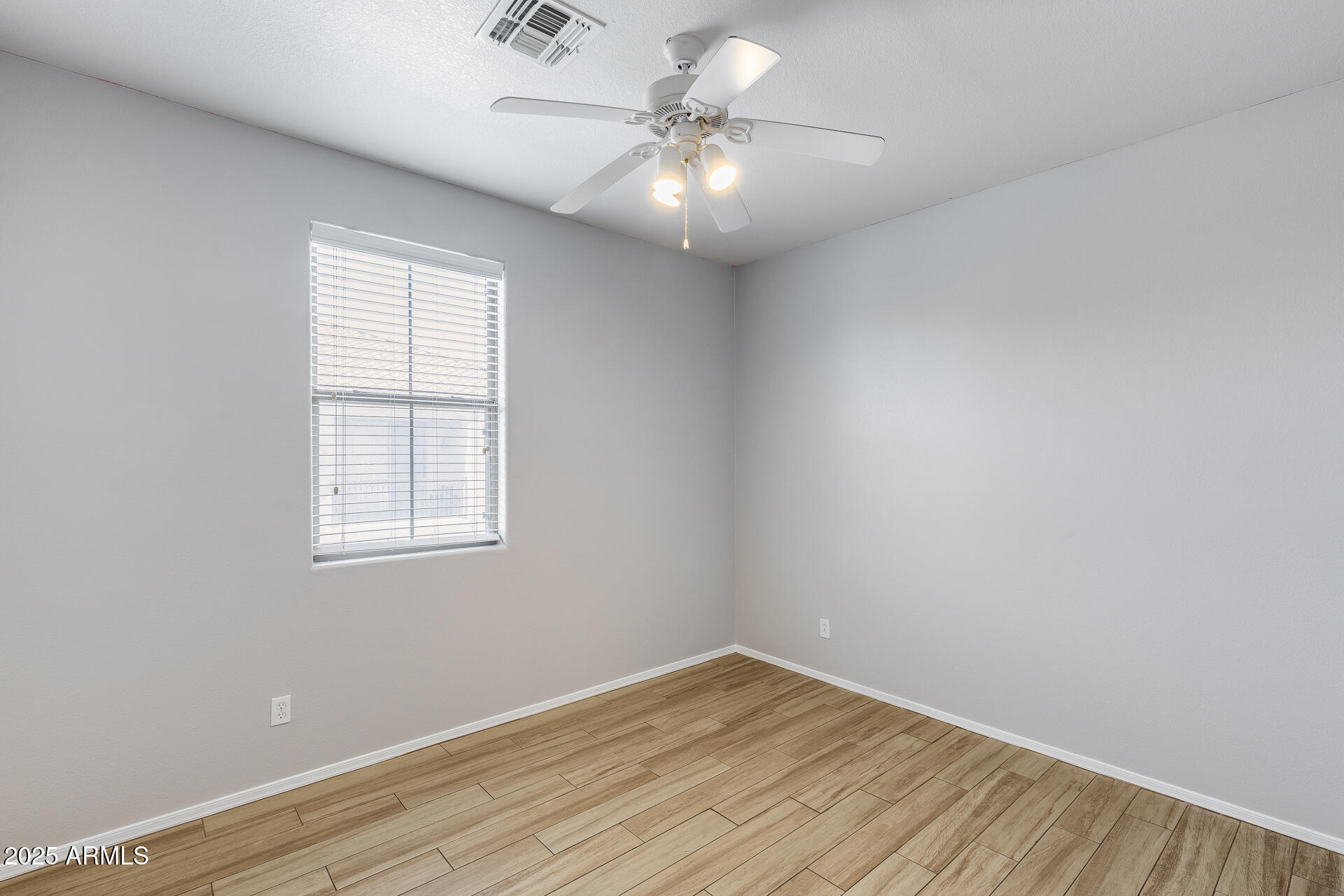 2941 East Darrow Street Phoenix, AZ 85042 - Photo 32 of 48 an empty room with wooden floor and windows