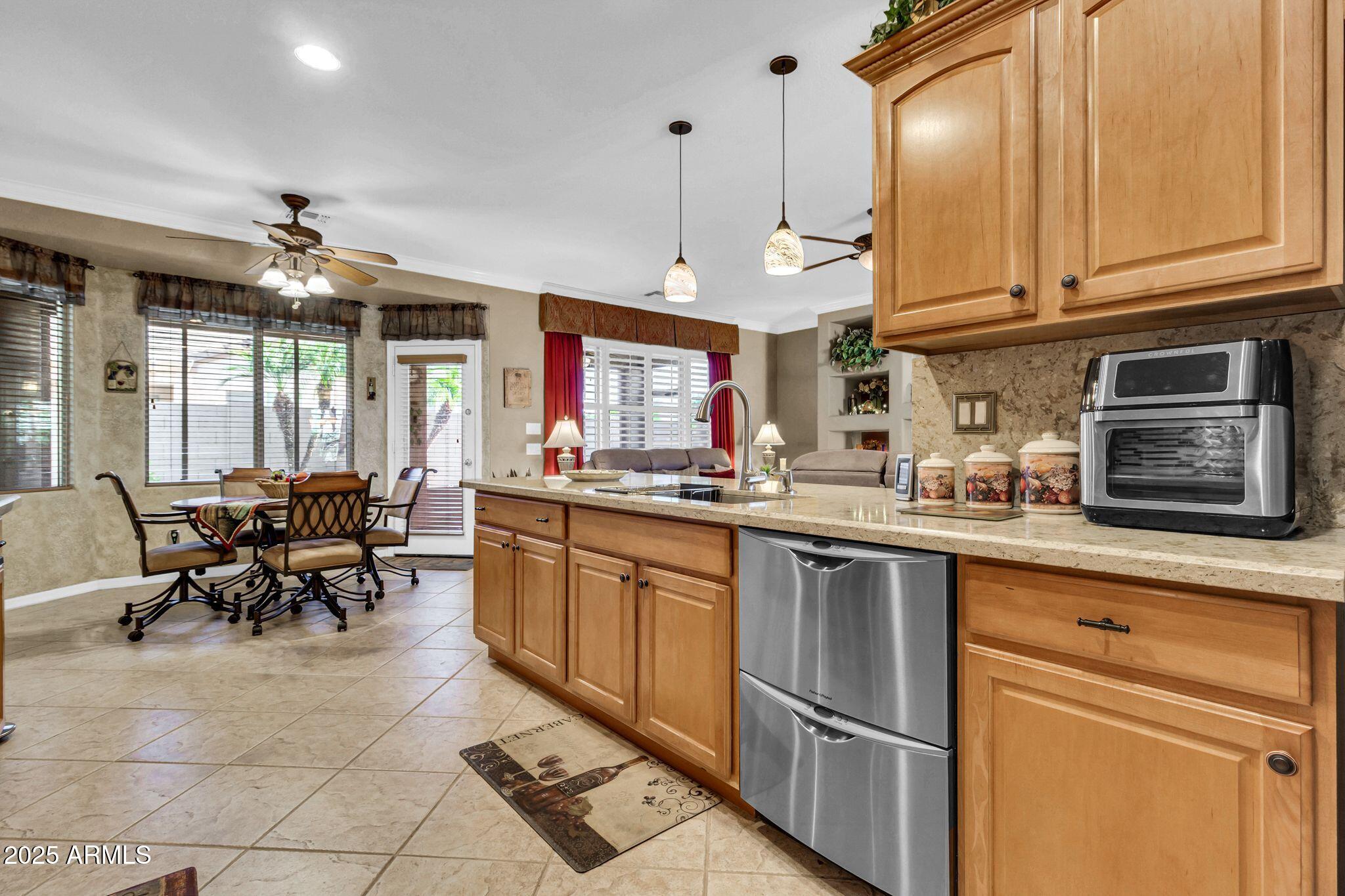 6959 South Rincon Drive Chandler, AZ 85249 - Photo 12 of 38 a kitchen with stainless steel appliances granite countertop a stove top oven a sink dishwasher and cabinets with wooden floor