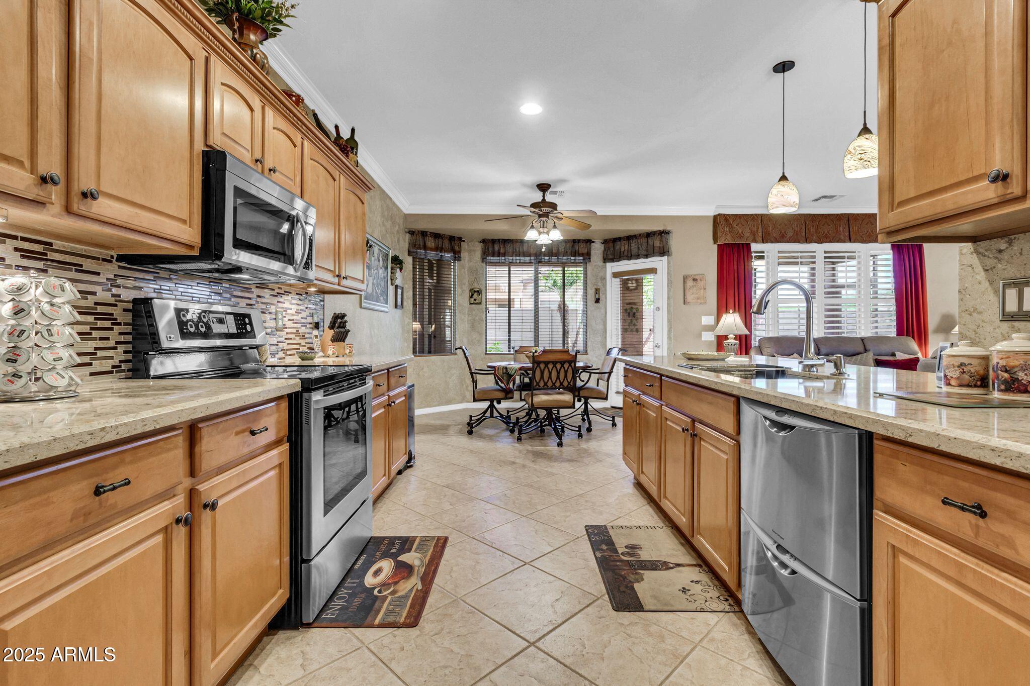 6959 South Rincon Drive Chandler, AZ 85249 - Photo 13 of 38 a kitchen with stainless steel appliances granite countertop a sink and cabinets