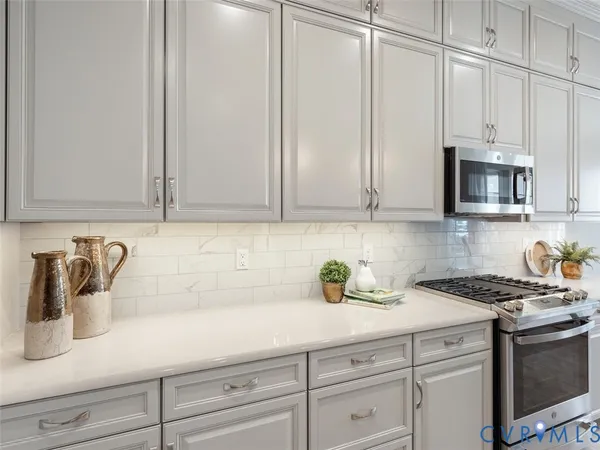 a kitchen with stainless steel appliances white cabinets and a stove top oven