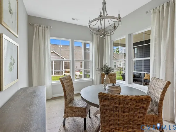 a dining room with furniture a chandelier and window