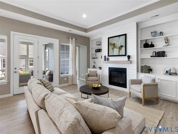 a living room with furniture a fireplace and a large window