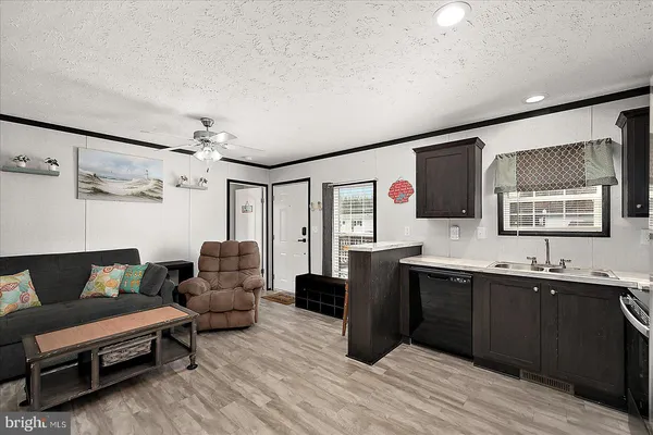 a living room with furniture a flat screen tv and kitchen view