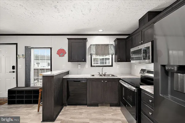 a kitchen with stainless steel appliances a sink stove and refrigerator