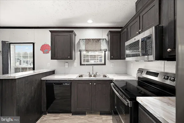 a kitchen with a sink stove and microwave