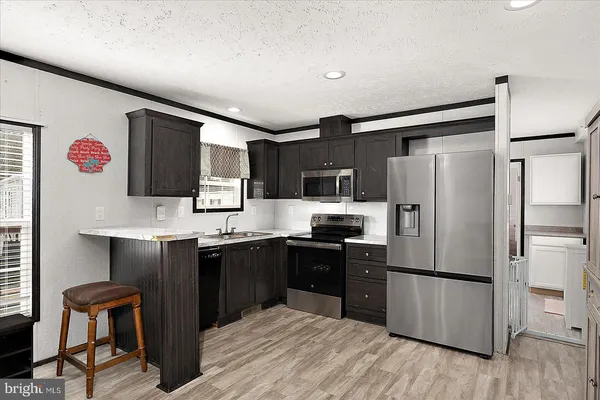 a kitchen with stainless steel appliances a refrigerator stove microwave and sink