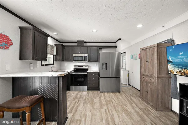 a kitchen with stainless steel appliances kitchen island granite countertop a refrigerator stove microwave and sink