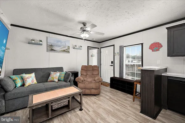 a living room with furniture ceiling fan and a wooden floor