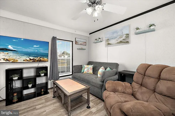 a living room with furniture a ceiling fan and a rug