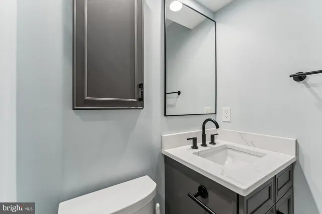 a bathroom with a sink toilet and mirror