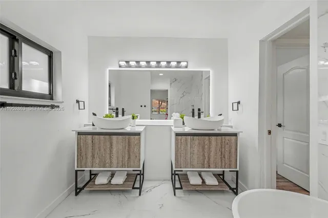 a bathroom with a sink a mirror and a bath tub
