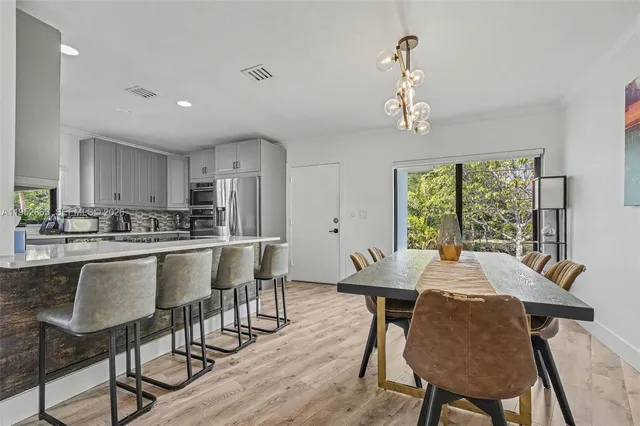 a kitchen with a dining table cabinets appliances and a window
