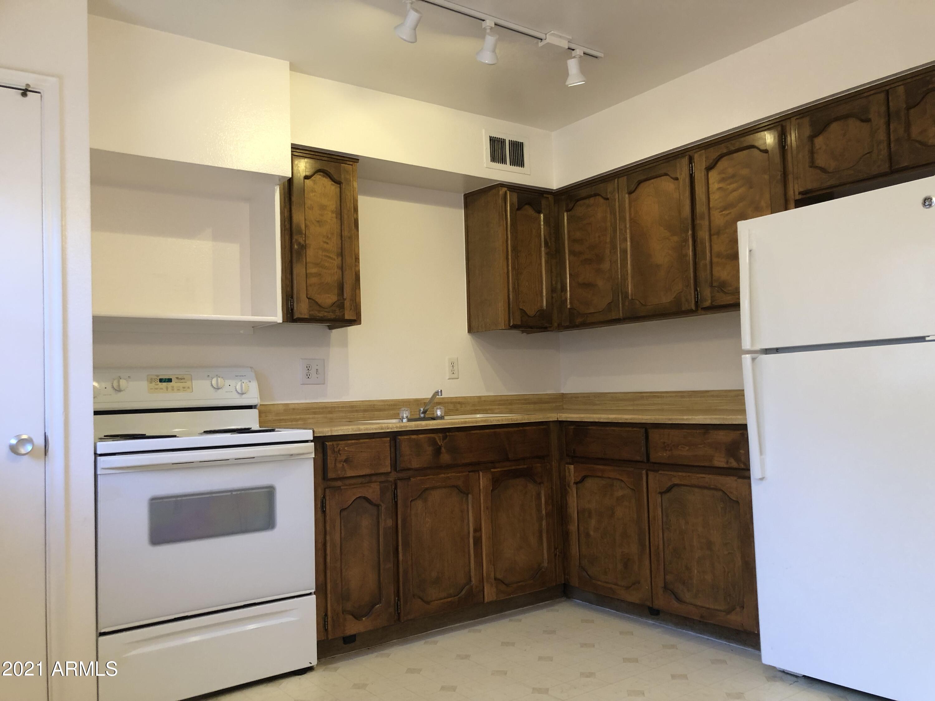 3031 South Rural Road, Unit 41 Tempe, AZ 85282 - Photo 6 of 23 a kitchen with a sink a stove and a refrigerator
