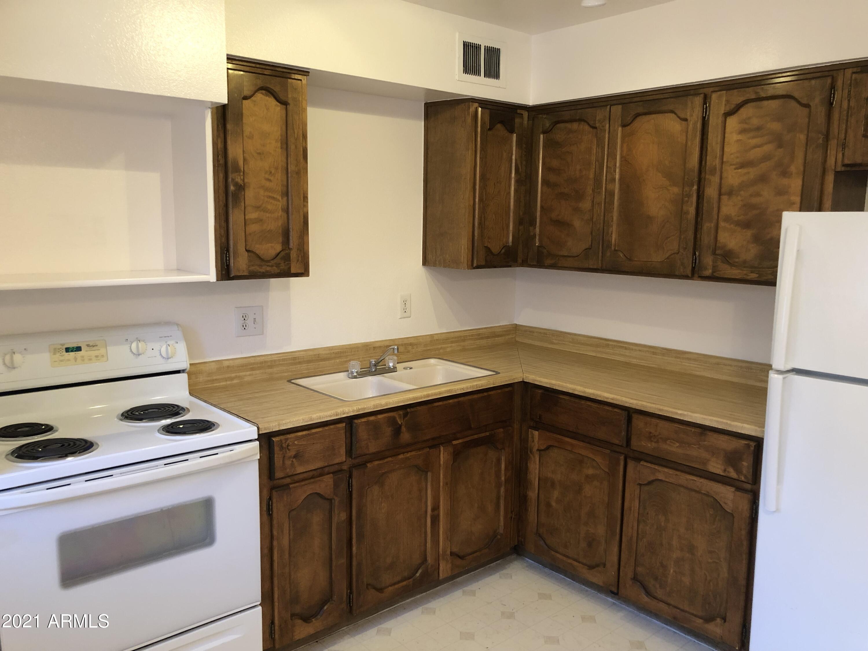 3031 South Rural Road, Unit 41 Tempe, AZ 85282 - Photo 8 of 23 a kitchen with a sink stove and cabinets
