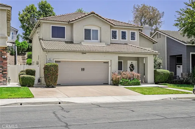 a front view of a house with a garden and yard
