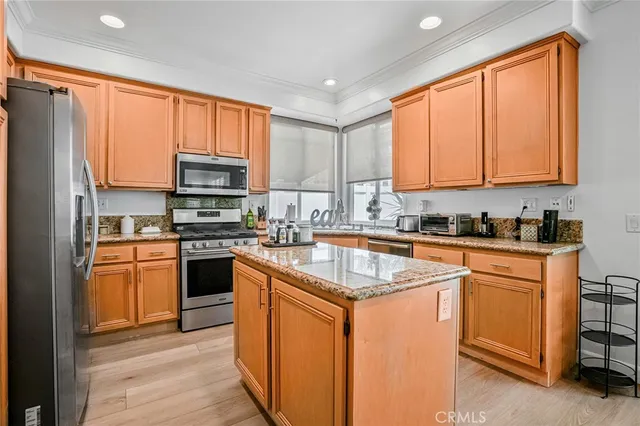 a kitchen with stainless steel appliances granite countertop a stove a sink dishwasher and a refrigerator