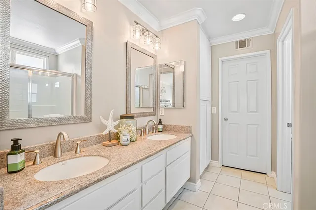 a bathroom with a granite countertop double vanity sink and a mirror