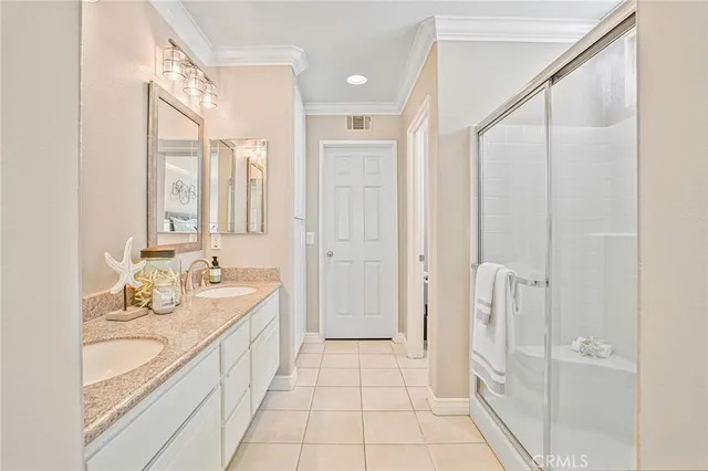 a spacious bathroom with a double vanity sink a mirror and a shower